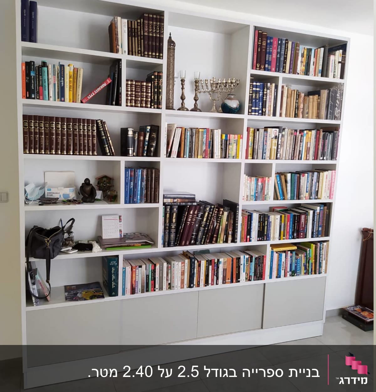 ארון ספרים לבן עם מדפים מלאים בספרים